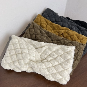 Detail of cross-knot knitted headbands in cream, olive green, yellow and grey colors