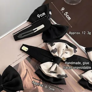 Set di fermagli per capelli con fiocchi neri e maculati su un vassoio elegante
