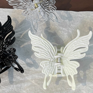 Close-up of butterfly hair claws in black, cream and clear with realistic wing textures