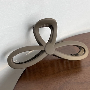 Close-up of matte brown butterfly hair claw clip for long hair on wooden table