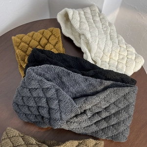 Macro detail of knit headbands showing bubble texture and cross design in various colors