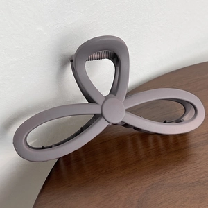 Detailed macro view of matte grey-purple hair claw clip with internal metal spring structure