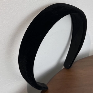 Close-up of a thick black velvet headband showing its vintage French style texture