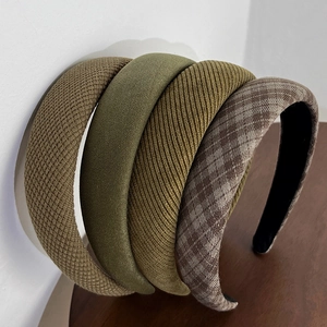 Detail showing the thick sponge headband textures in green plaid and earthy fabrics