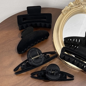 Ensemble de pinces à cheveux floquées noires vintage sur une table en bois foncé