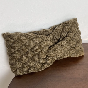 Detail showing thick olive green knitted headband with twist knot and texture