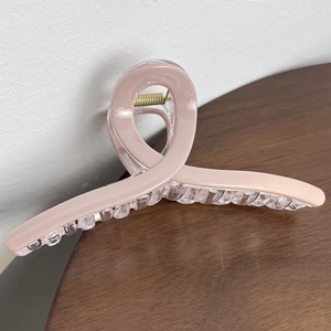 Detail view of 13cm shark hair claw clip in pink and clear resin with gold spring