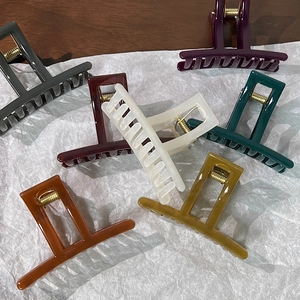 Set of seven glossy square hair claws in jelly colors on a textured background
