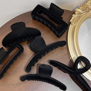 Détail de diverses pinces à cheveux floquées noires sur une table en bois vintage