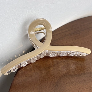 Detail of 13cm large hair claw clip with khaki finish and golden metal spring