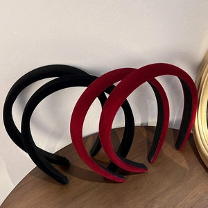 Detail view of retro red and black velvet headbands on a wooden table display