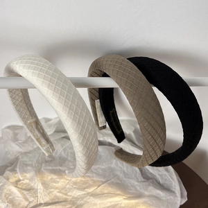 Detail view of French padded plaid headbands in white, khaki, and black fabric