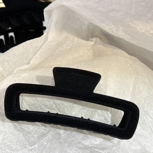 Détail de la texture floquée noire sur la pince à cheveux rectangulaire minimaliste en vue