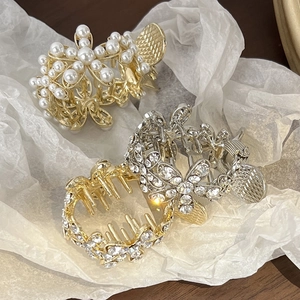 Détails de pinces à cheveux en métal avec perles et fleurs en strass sur papier blanc