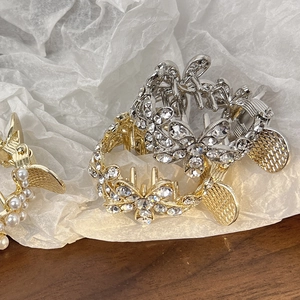 Détail de pinces à cheveux papillon avec cristaux et perles sur une surface en bois