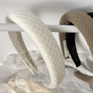 Close-up of padded sponge headbands featuring diamond lattice weave in beige and black