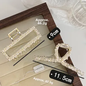 Detail view of pearl hair claws with size and weight specs on a beige velvet tray