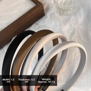 Detail view of 1.5cm wide satin headbands showing dimensions and handmade label