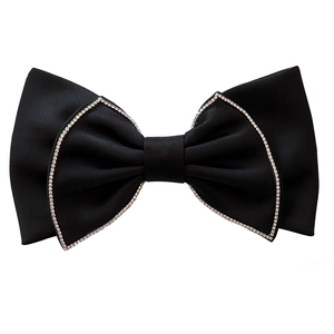 Close-up of black satin bow hair clip with sparkling silver rhinestone trim details