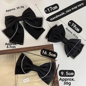 Detailed comparison of three black satin bow clips with rhinestones in different sizes
