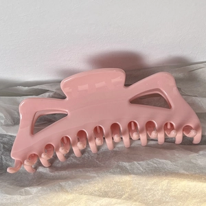 Detail view of a large light pink butterfly hair claw clip with a glossy finish