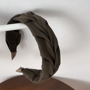 Detail of dark coffee brown pleated headband with thick twisted weave texture