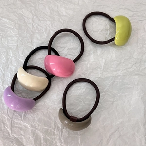 Dettaglio di un set da cinque elastici per capelli dai colori pastello con decori acrilici