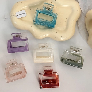 Detail view of six rectangle hollow hair claws in assorted pastel marble colors