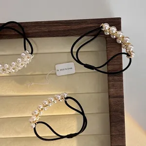 Élastique à cheveux élégant avec fleurs en perles et accents dorés sur un plateau