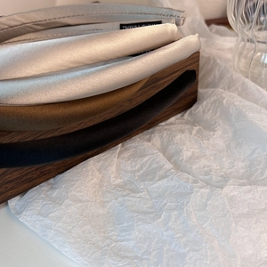 Macro shot of handmade satin headbands showing smooth texture and handmade labels