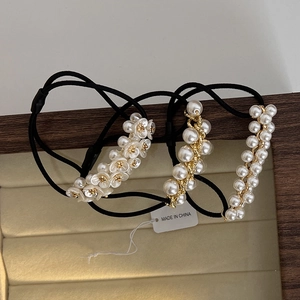 Détail de trois chouchous en perles avec accents dorés sur un plateau élégant