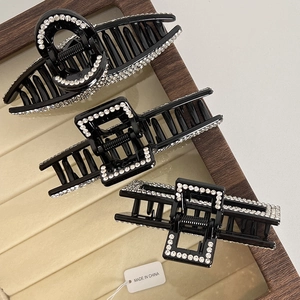 Detailed view of three French style black shark hair clips with sparkling rhinestones