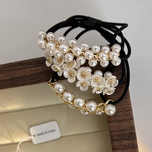 Détail de l'ensemble de trois chouchous élégants avec perles et fleurs dorées