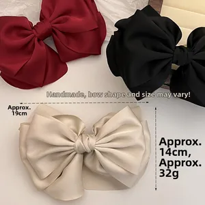 Macro detail of large satin bow hair clip measuring 19cm by 14cm with handmade silk texture
