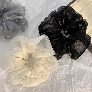 Detailopname van organza haarelastiekjes met parels in grijs, beige en klassiek zwart decor