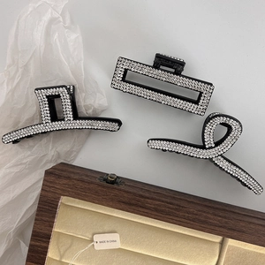 Three elegant black claw clips with sparkling rhinestones in geometric and twisted designs