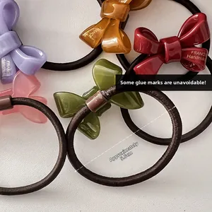 Detailed macro view of handmade acrylic bow hair ties with France lettering engraving