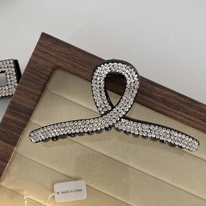 Close-up of elegant black twisted hair claw clip with pavé sparkling rhinestones