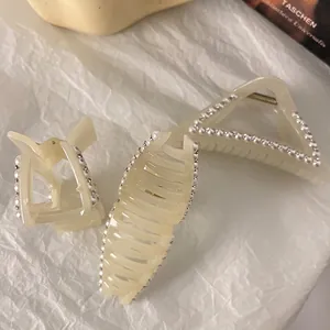 Ensemble de pinces à cheveux françaises crème avec perles et strass sur fond texturé