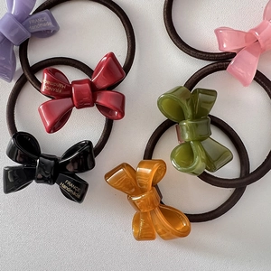 Close-up of colorful acrylic bow hair ties with France Handmade gold lettering