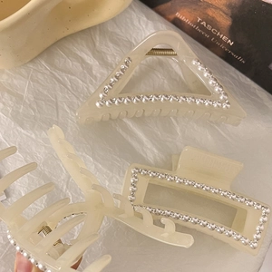 Vue détaillée des pinces à cheveux françaises avec perles et strass sur acétate crème