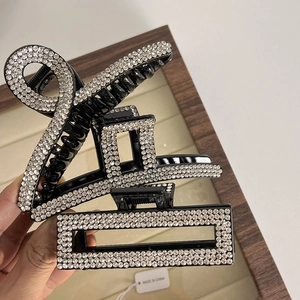 Detailed view of three French vintage hair claws with sparkling white rhinestones on black resin