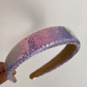 Detail of padded headband featuring iridescent sequins and soft brown velvet lining