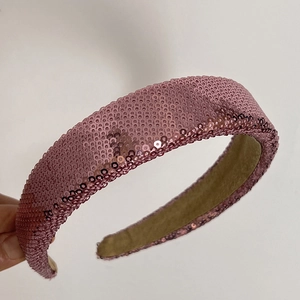Close-up detail of pink sequin headband with soft fabric lining and shiny reflective finish
