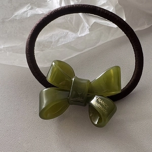 Detail of olive green acrylic bow hair tie with France Handmade gold lettering