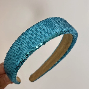 Detailed close-up showing blue sequins and soft beige velvet lining on the wide headband