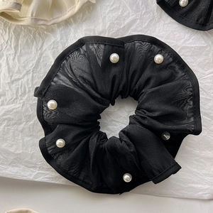 Detail of black organza scrunchie featuring white pearls and delicate lace edging