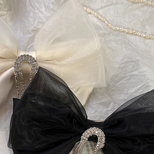 Detail of vintage mesh bow hair clips with rhinestones in black and cream beige