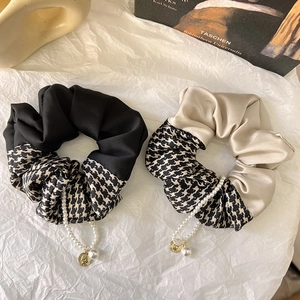 Detail of satin scrunchies with houndstooth pattern, faux pearls, and vintage coins