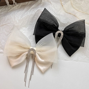 Detail of elegant black and champagne mesh bow hair clips with dangling rhinestone fringe